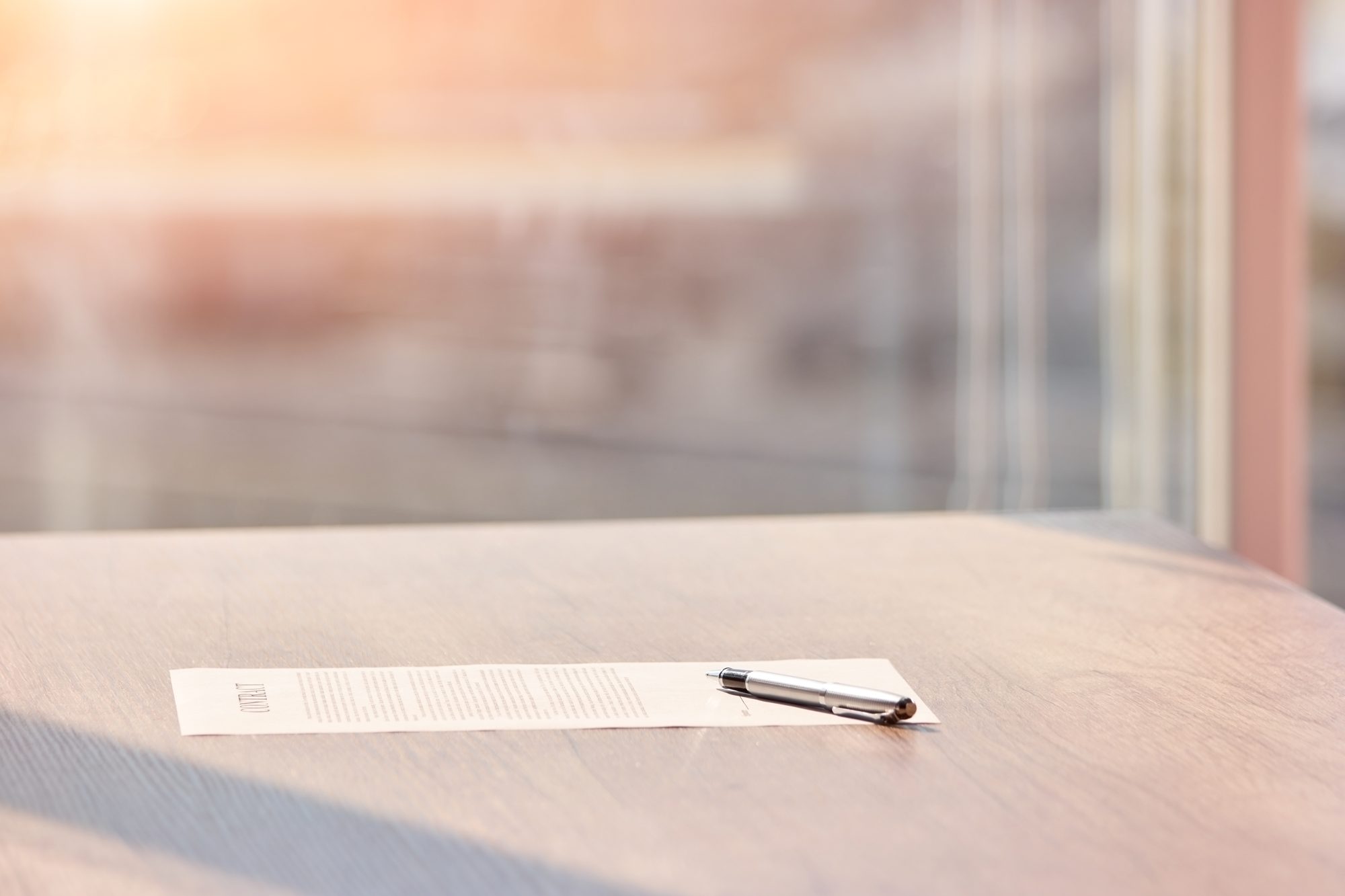A contract document and pen on a desk